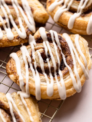 A baked and glazed puff pastry cinnamon roll.