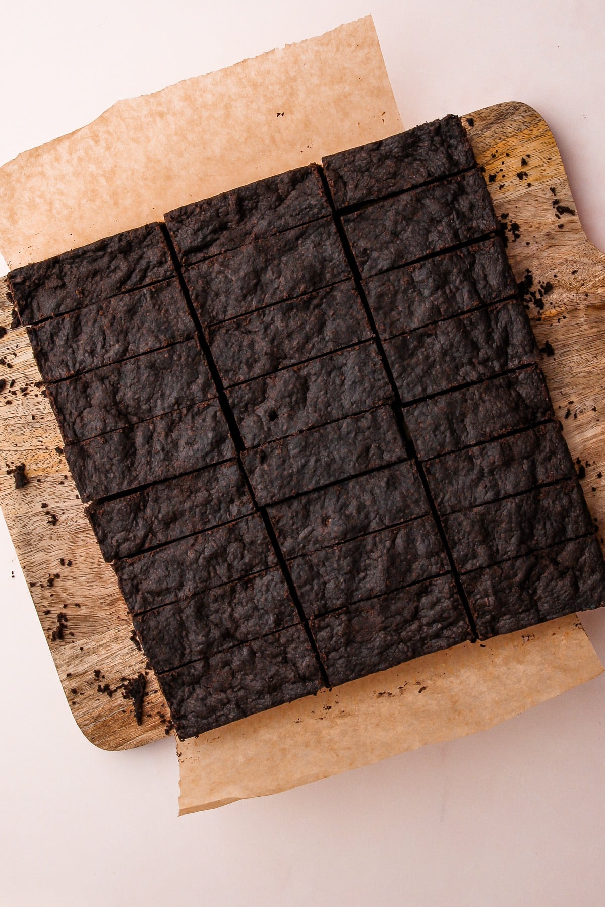 Baked chocolate shortbread cookies on a cutting board, cut into rectangles.