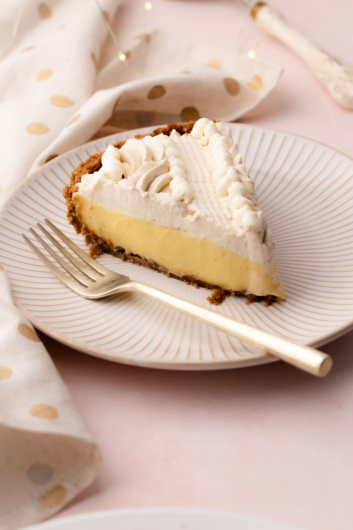 A slice of eggnog cream pie on a plate with a fork.