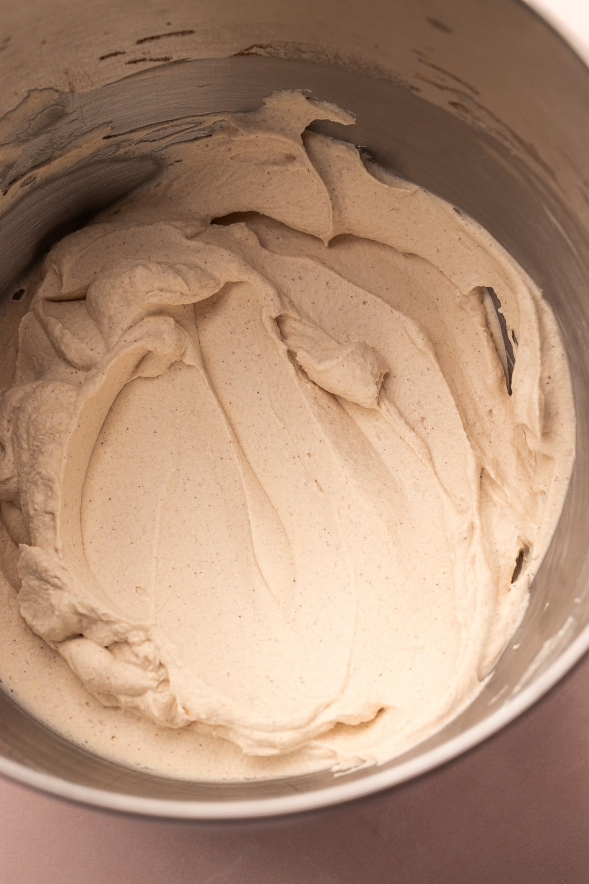 A bowl filled with bourbon brown sugar whipped cream for eggnog cream pie.