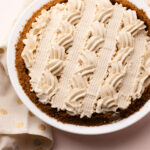 An eggnog cream pie decorated with piped whipped cream.