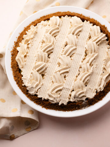 An eggnog cream pie decorated with piped whipped cream.