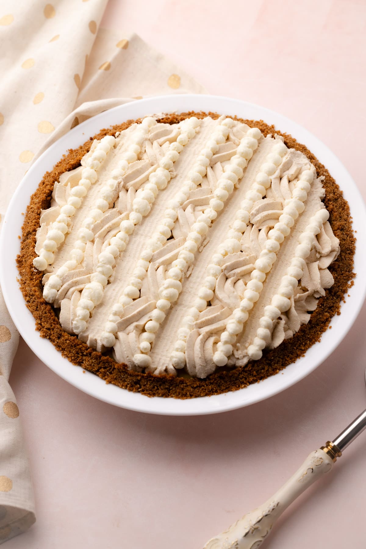 An eggnog cream pie decorated with piped whipped cream.