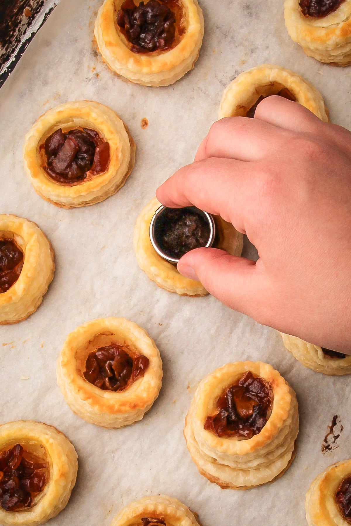 Pushing the baked puff pastry down to make room for the fig and goat cheese.
