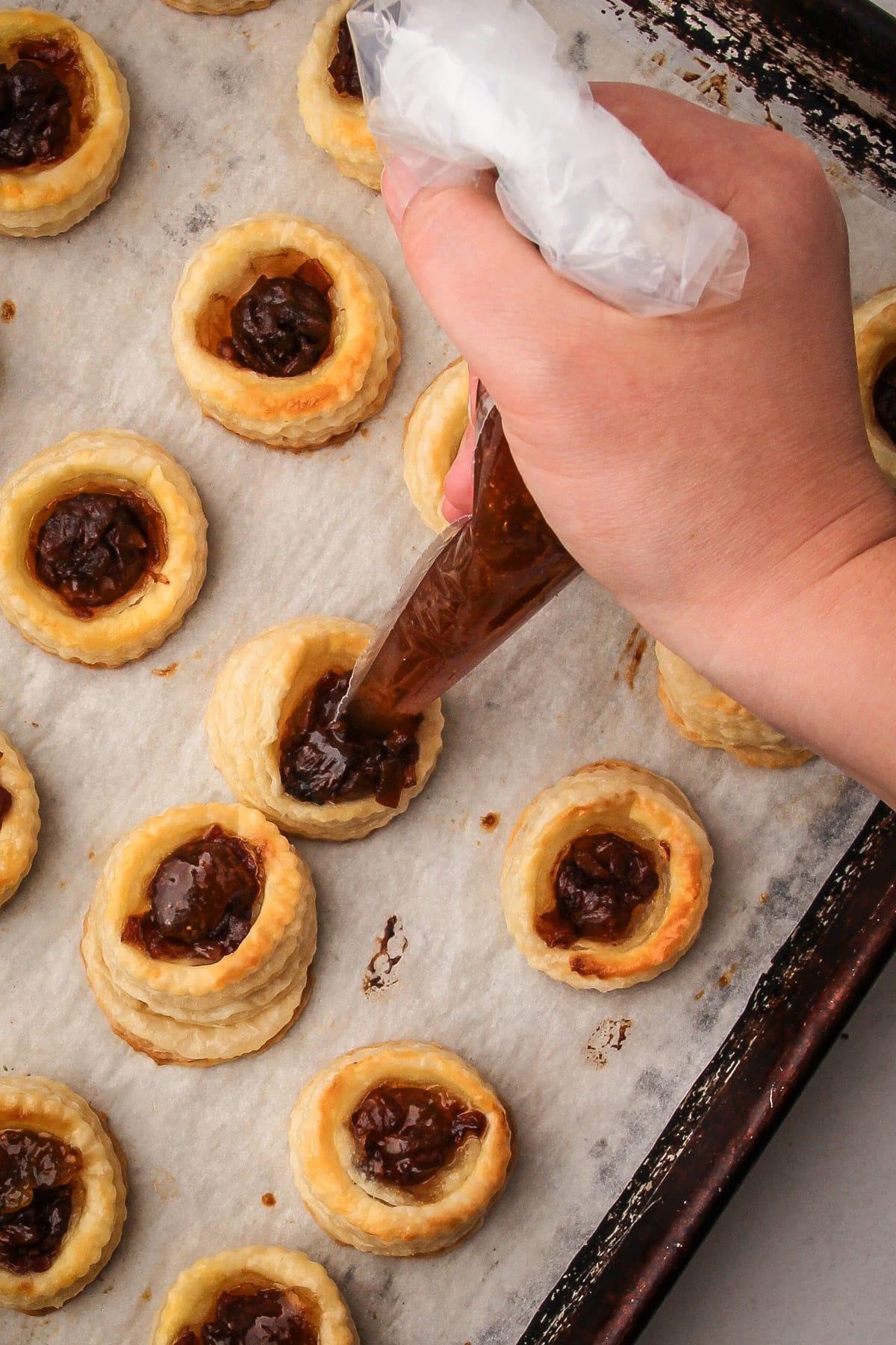 Filling puff pastry tarts with fig jam.