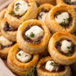 A platter of puff pastry goat cheese and fig tarts with a sprinkle of thyme.