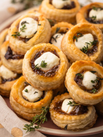 A platter of puff pastry goat cheese and fig tarts with a sprinkle of thyme.