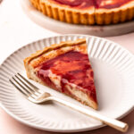 A sliced of baked mascarpone plum pie on a plate with a fork.