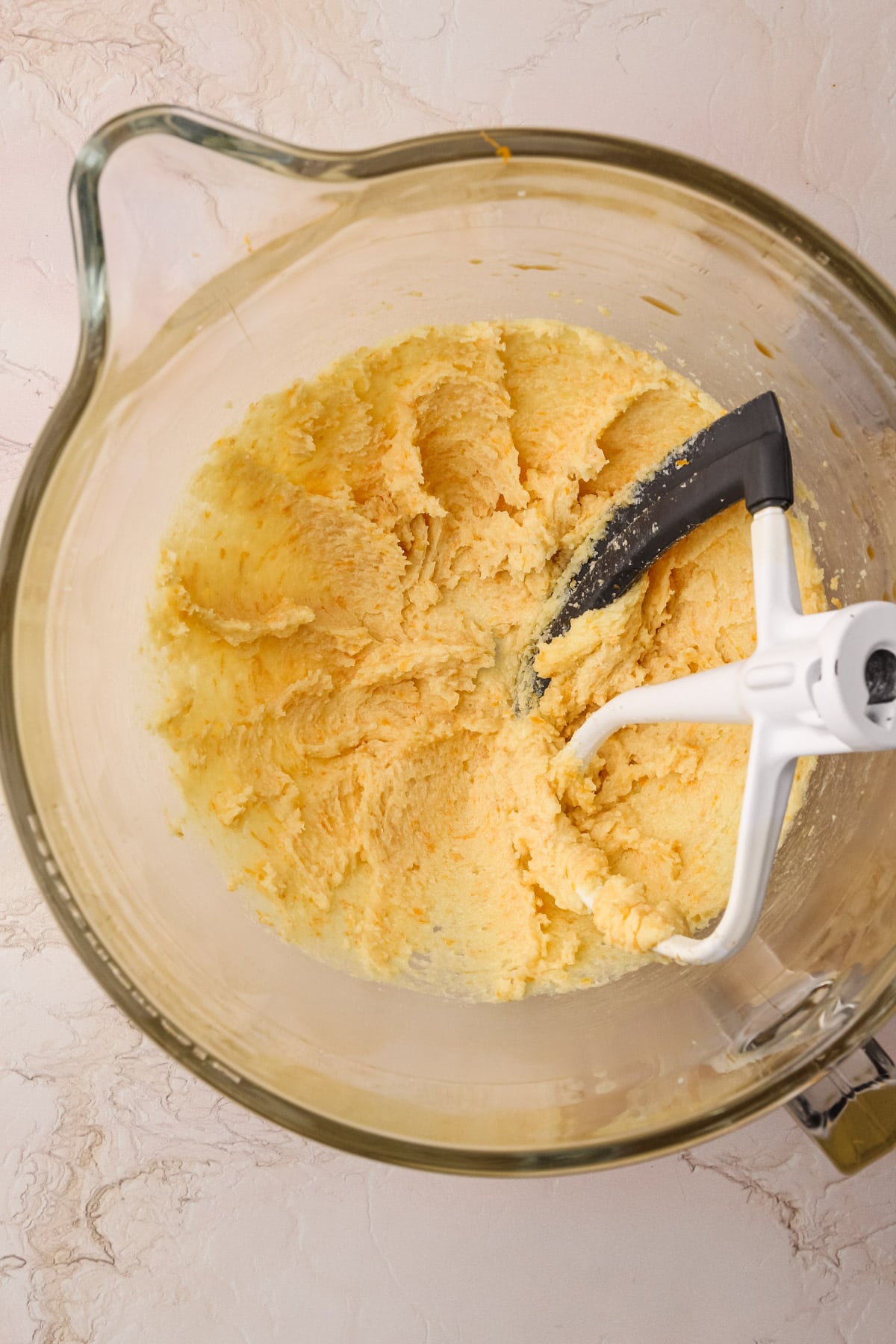 Creamed butter and orange extract in a mixing bowl.