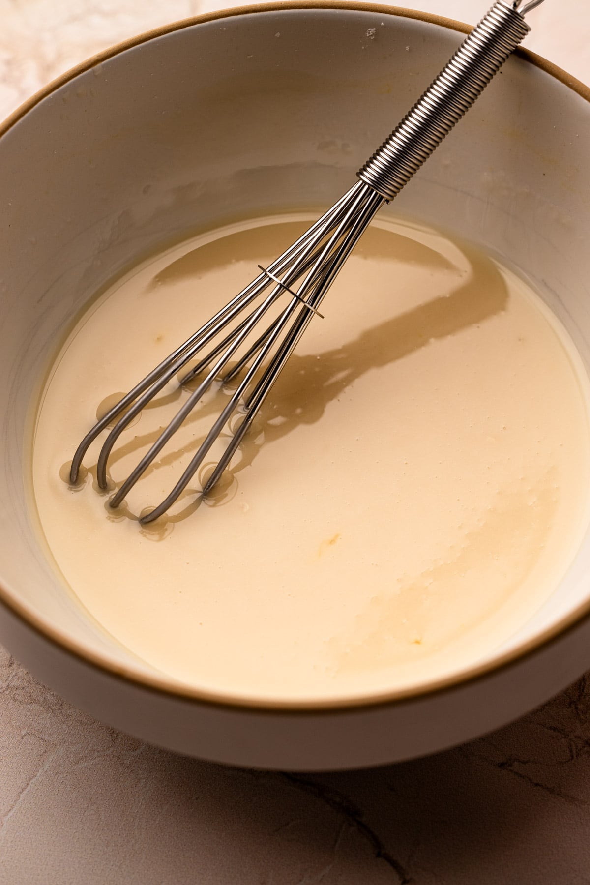 A bowl of orange glaze for orange cookies.