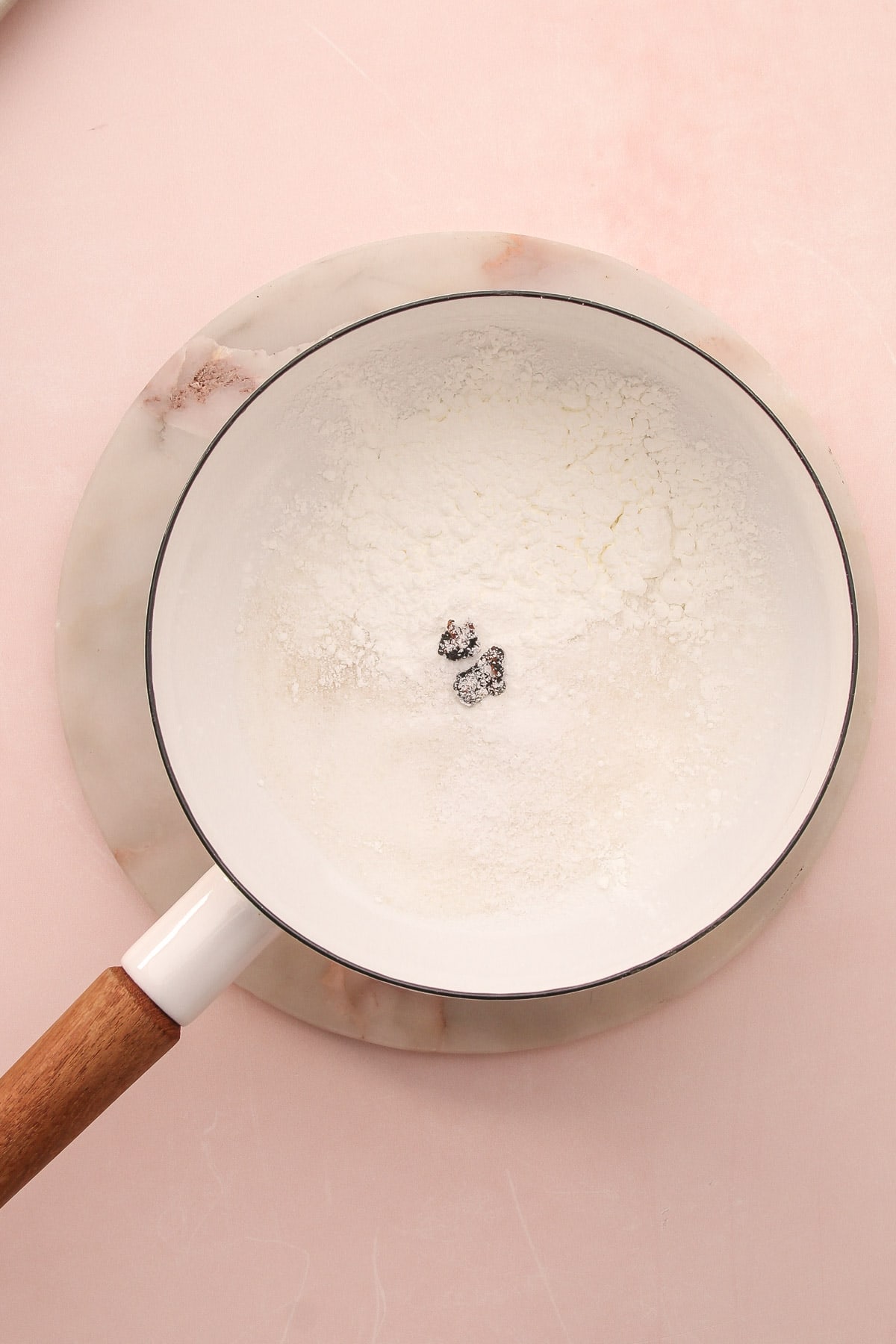 A saucepan with dry ingredients for homemade vanilla pudding.