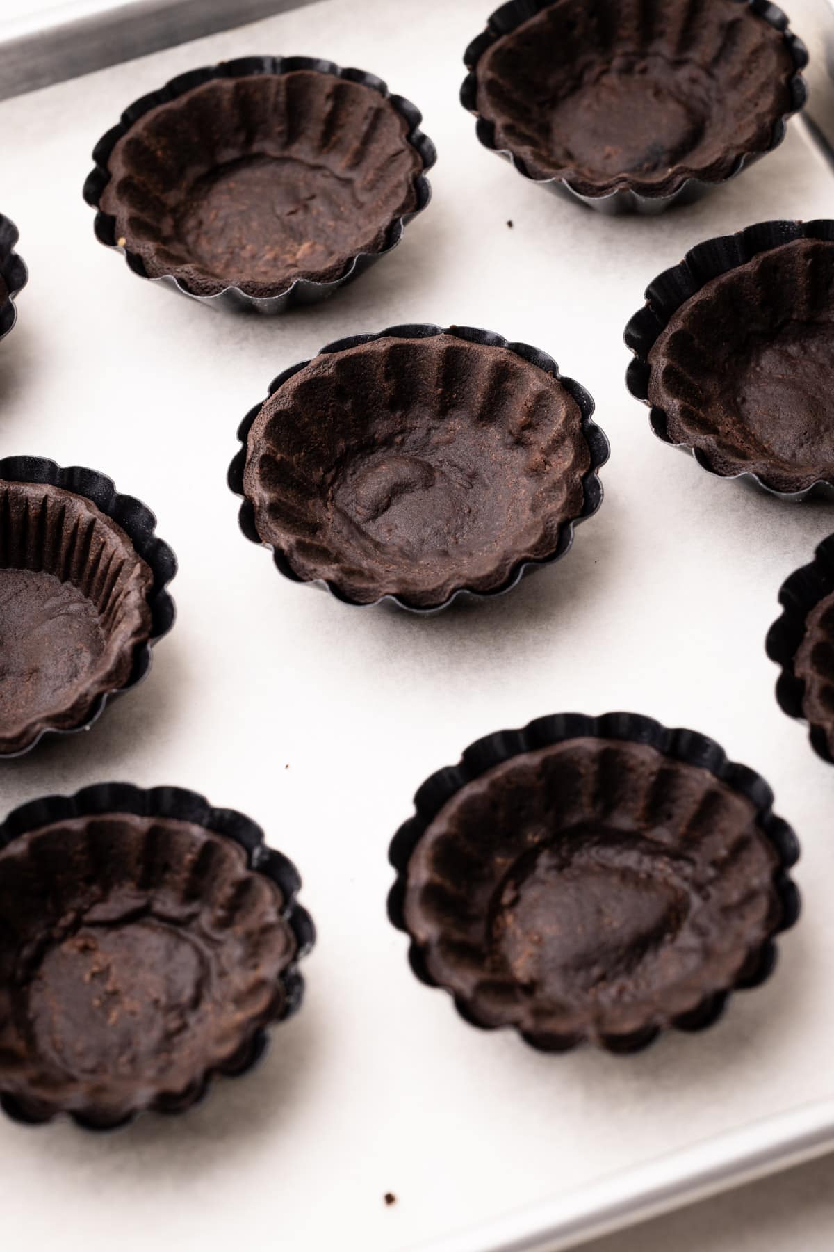 Blind-baked mini tart shells for chocolate strawberry tarts.