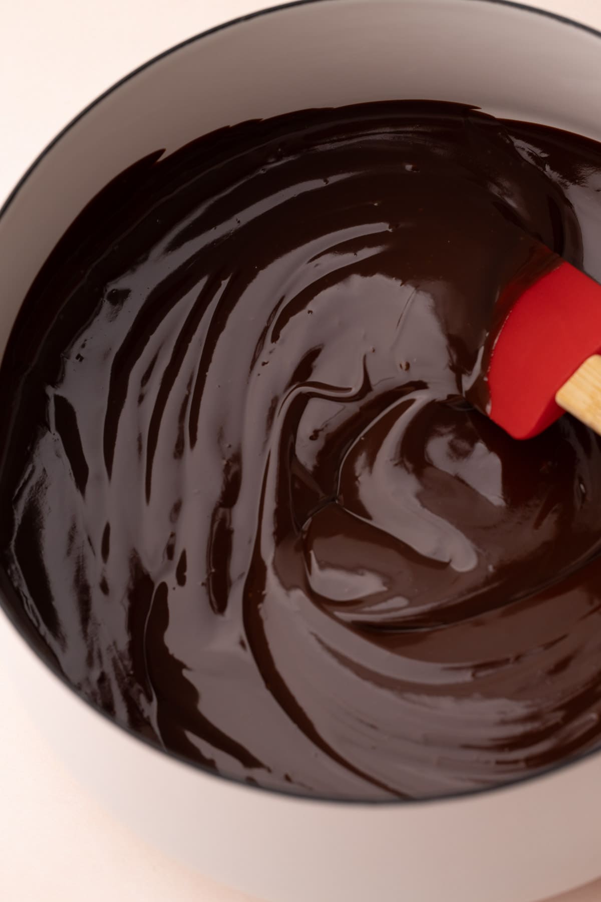 A saucepan filled with chocolate ganache for easy chocolate pie, with a rubber spatula in it.