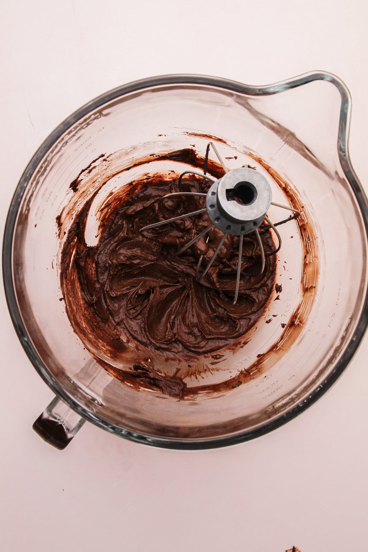 A stand mixer bowl with chocolate filling ingredients and a whisk attachment in it for easy chocolate pie.