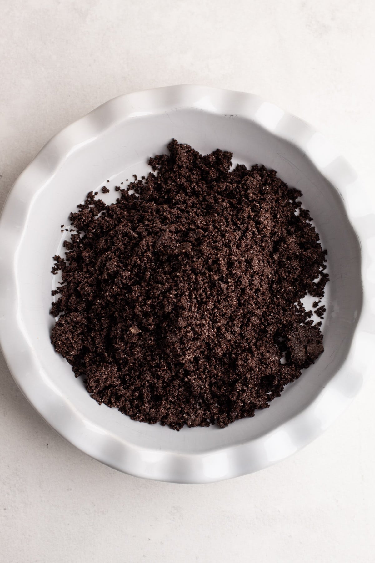 Oreo crumb mixture in a pie plate.