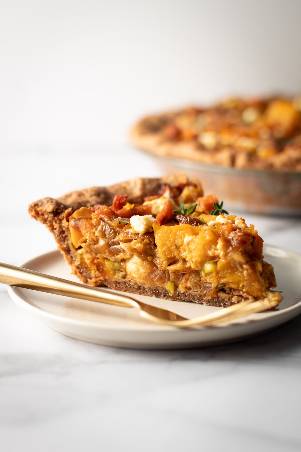A slice of savory butternut squash pie with caramelized onions and feta.