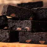 Stacks of homemade almond flour brownies on a cutting board.