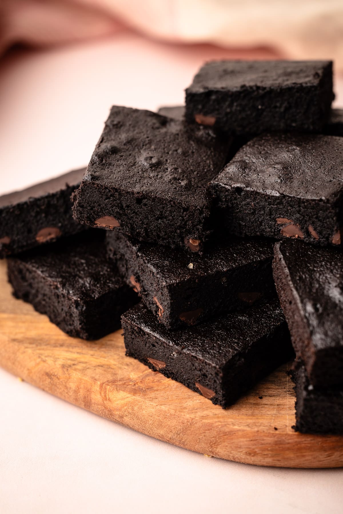 Stacks of homemade almond flour brownies on a cutting board.