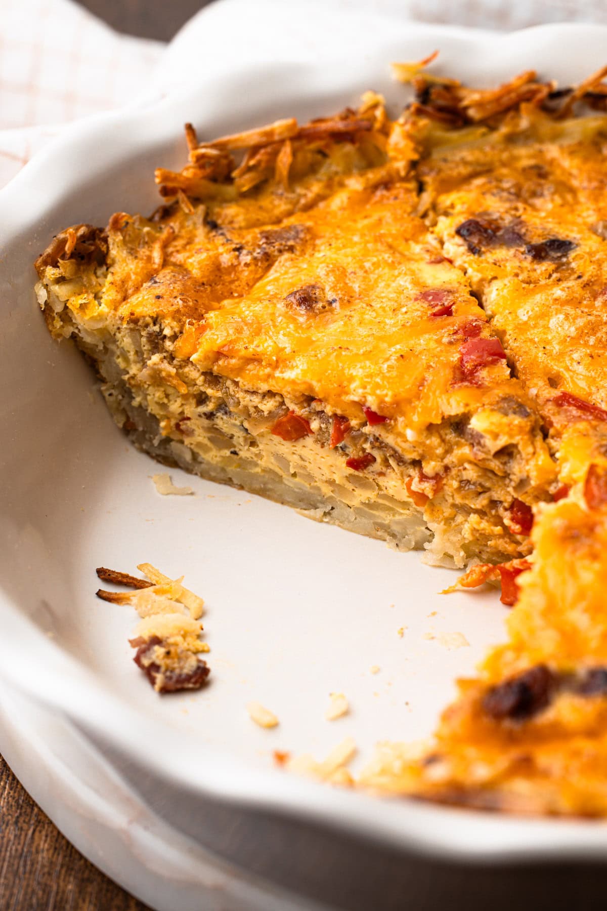 A slice of breakfast pie made with eggs, bacon and cheese.