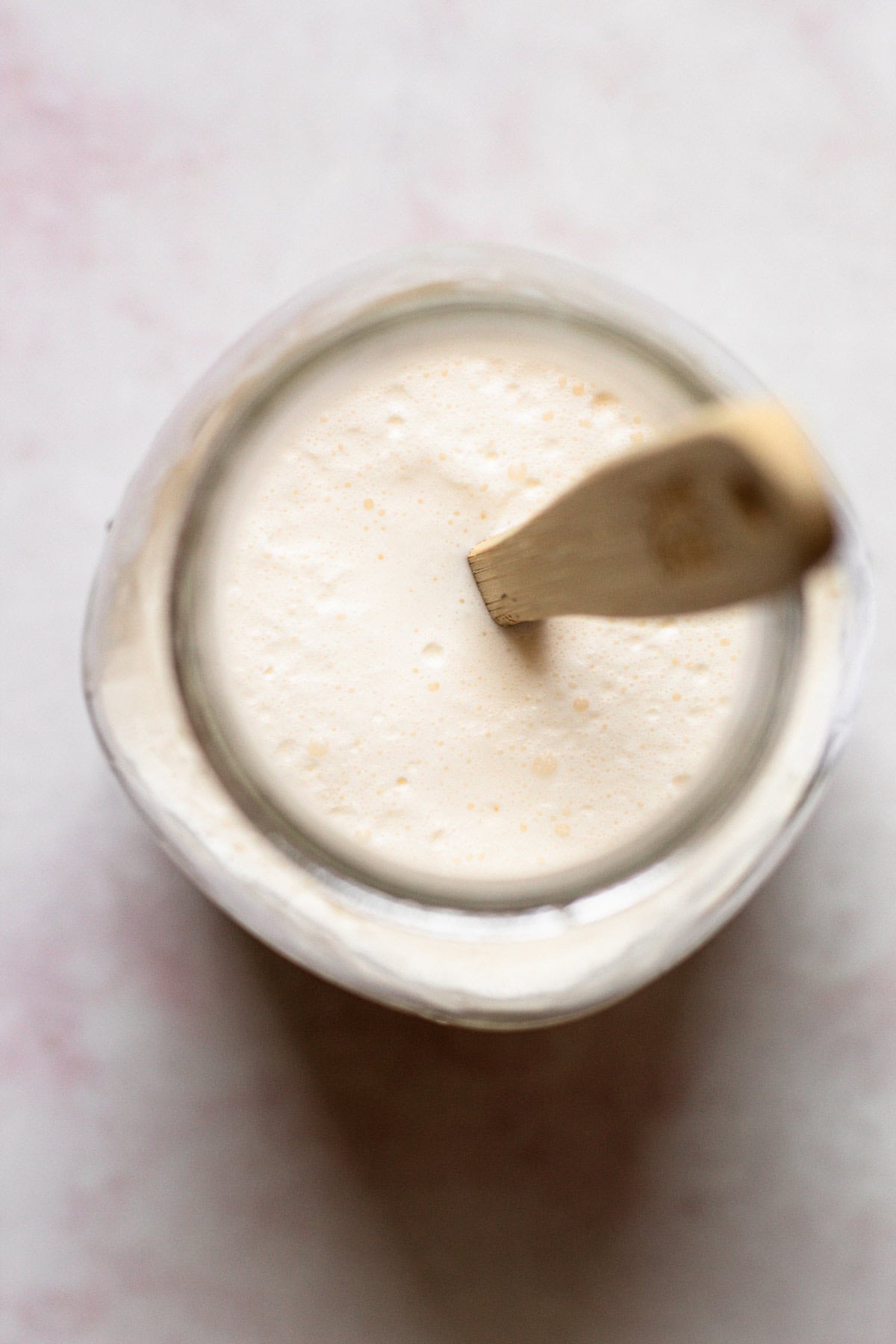 Homemade creme fraiche fermenting in a mason jar.