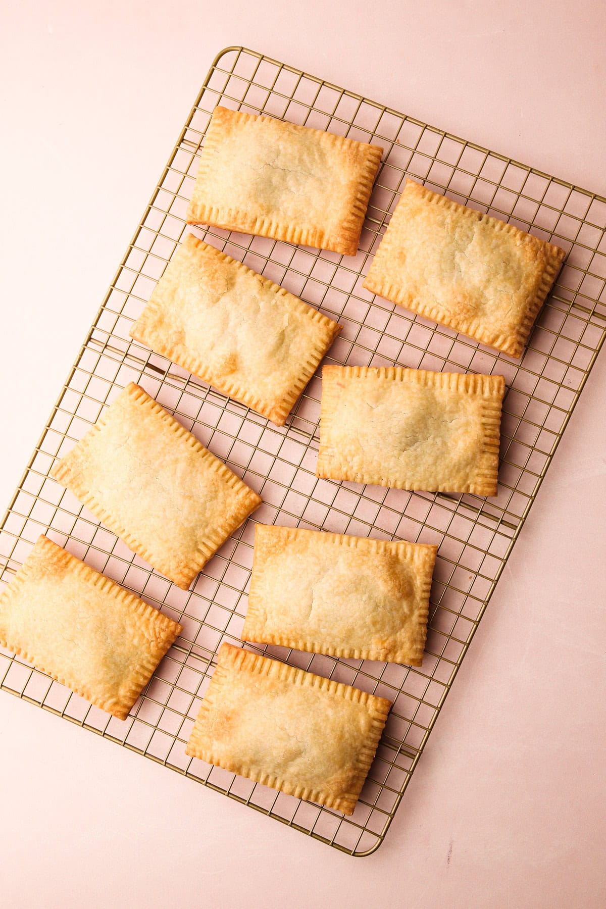 8 baked homemade pop tarts on a cooling rack.