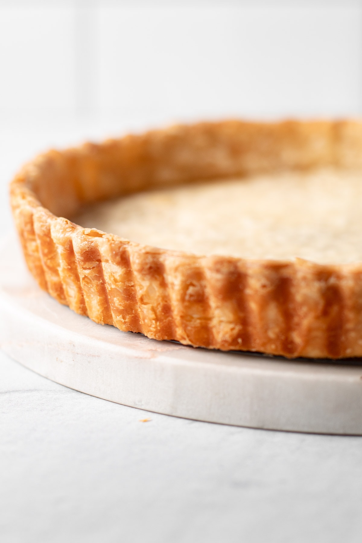 A blindbaked pate brisee tart that is empty.