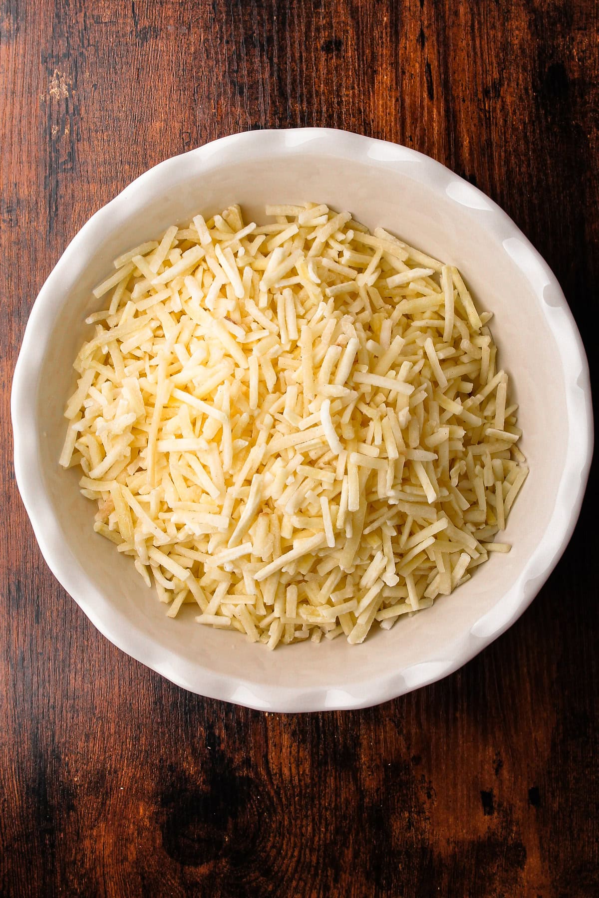 Frozen hashbrowns inside of a pie plate.