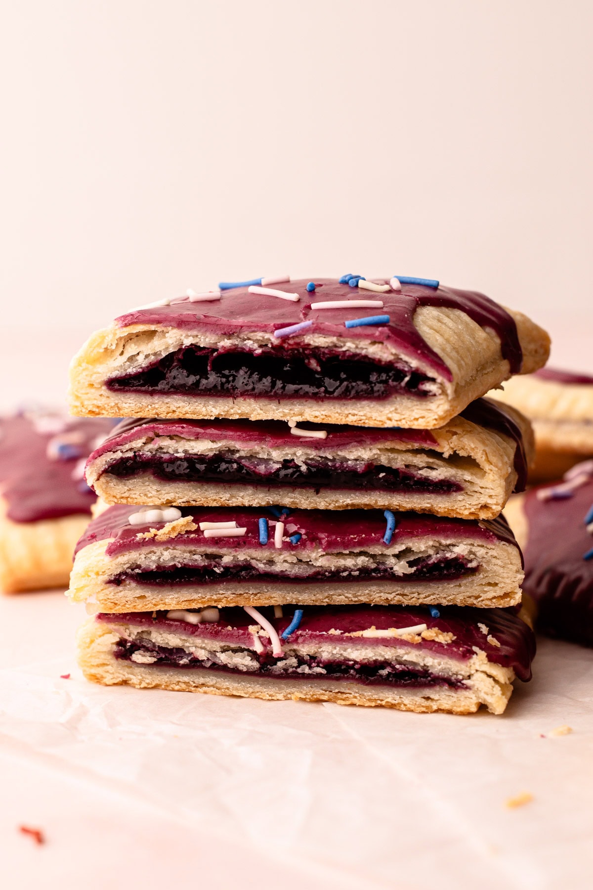 A stack of wild berry pop tarts cut open to reveal the berry filling.