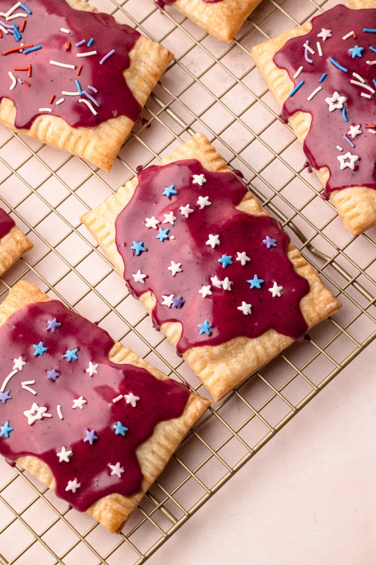 Baked and decorated berry pop tarts with sprinkles.