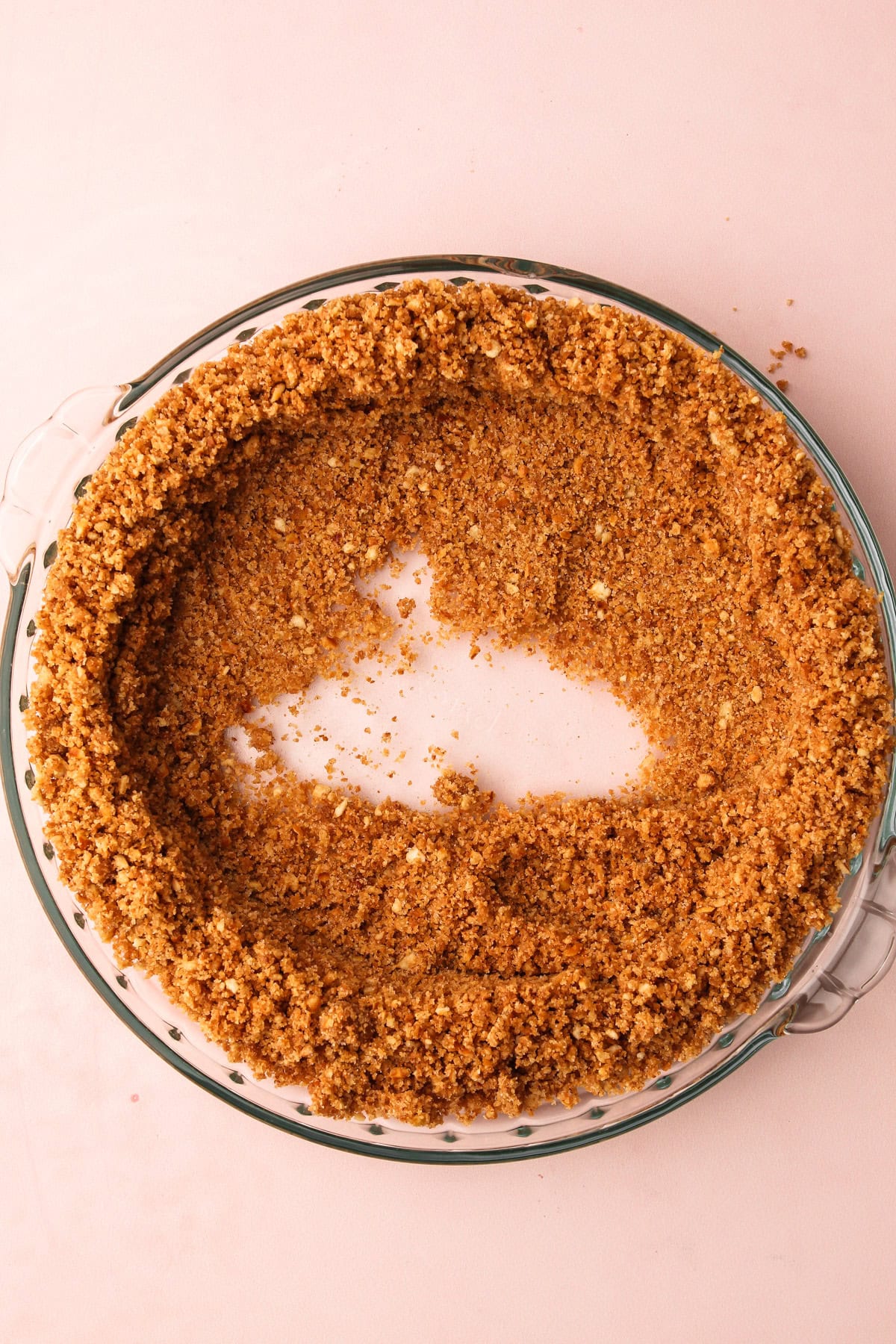 Forming a graham cracker crumb crust in a pie plate.