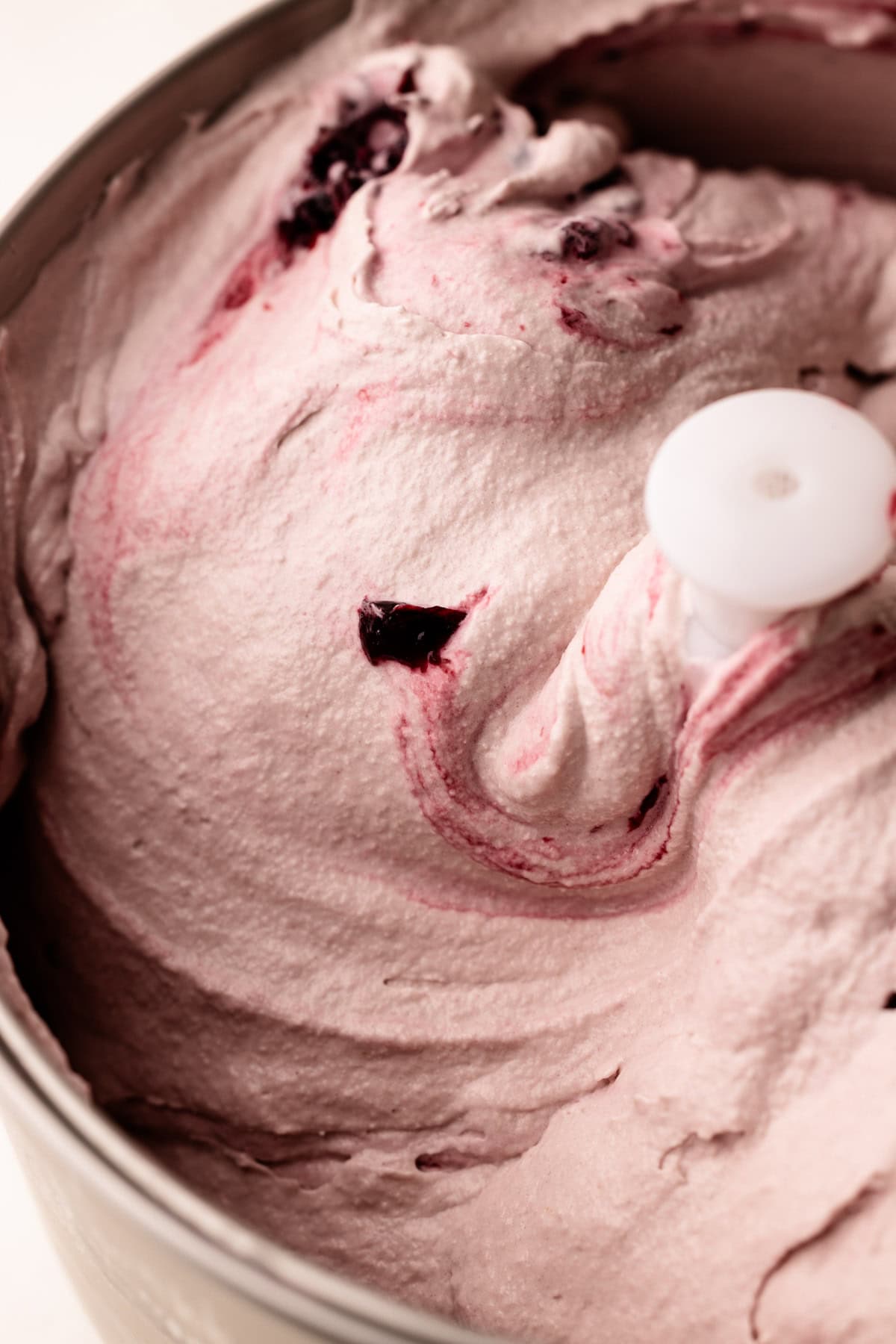 Spinning homemade cherry ice cream in an ice cream machine.