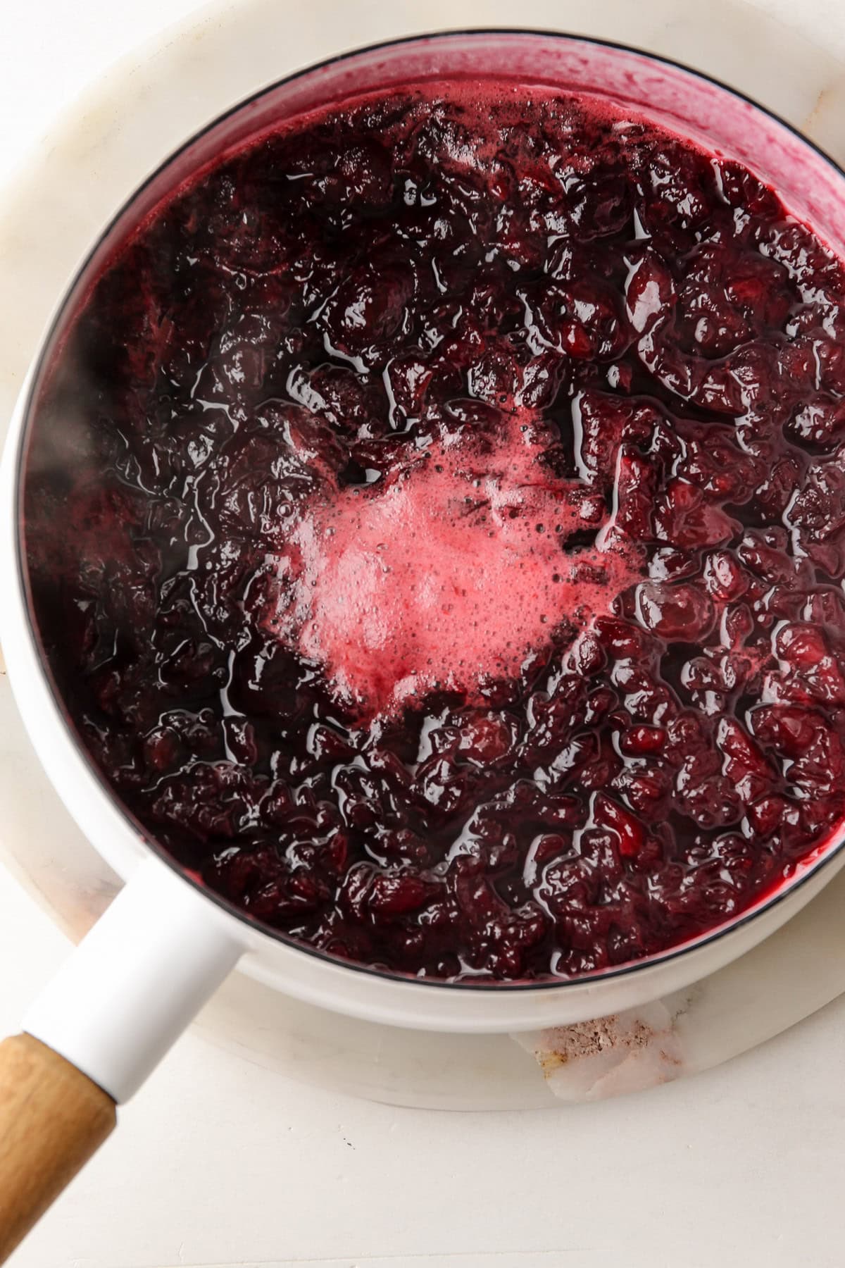 Cooking cherries in a pot for a cherry ice cream recipe.