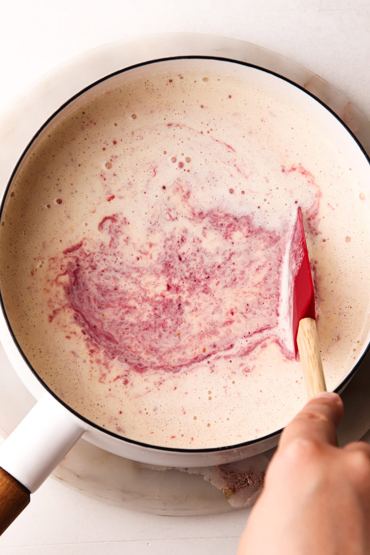 Ingredients for cherry ice cream in a pot.