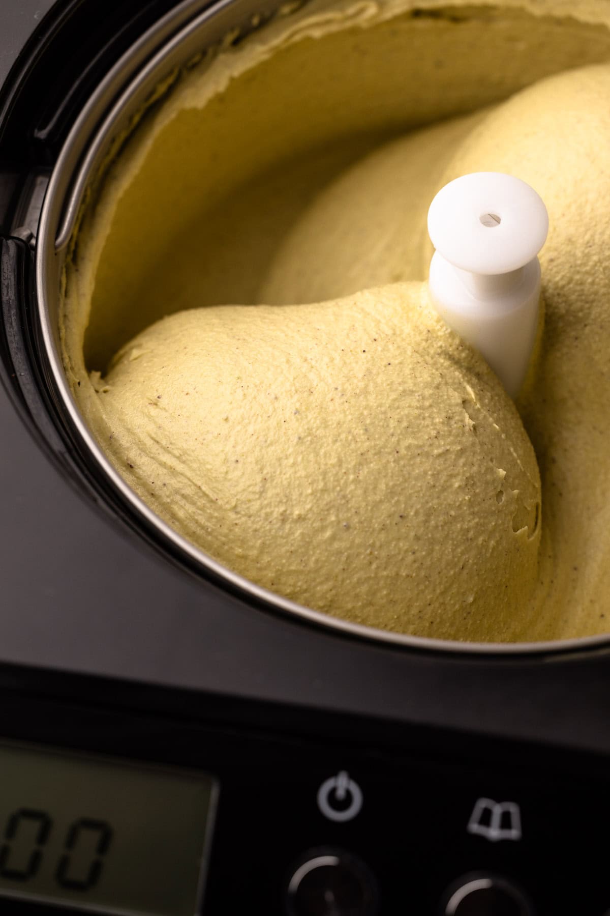 Spinning homemade pistachio ice cream in an ice cream maker.