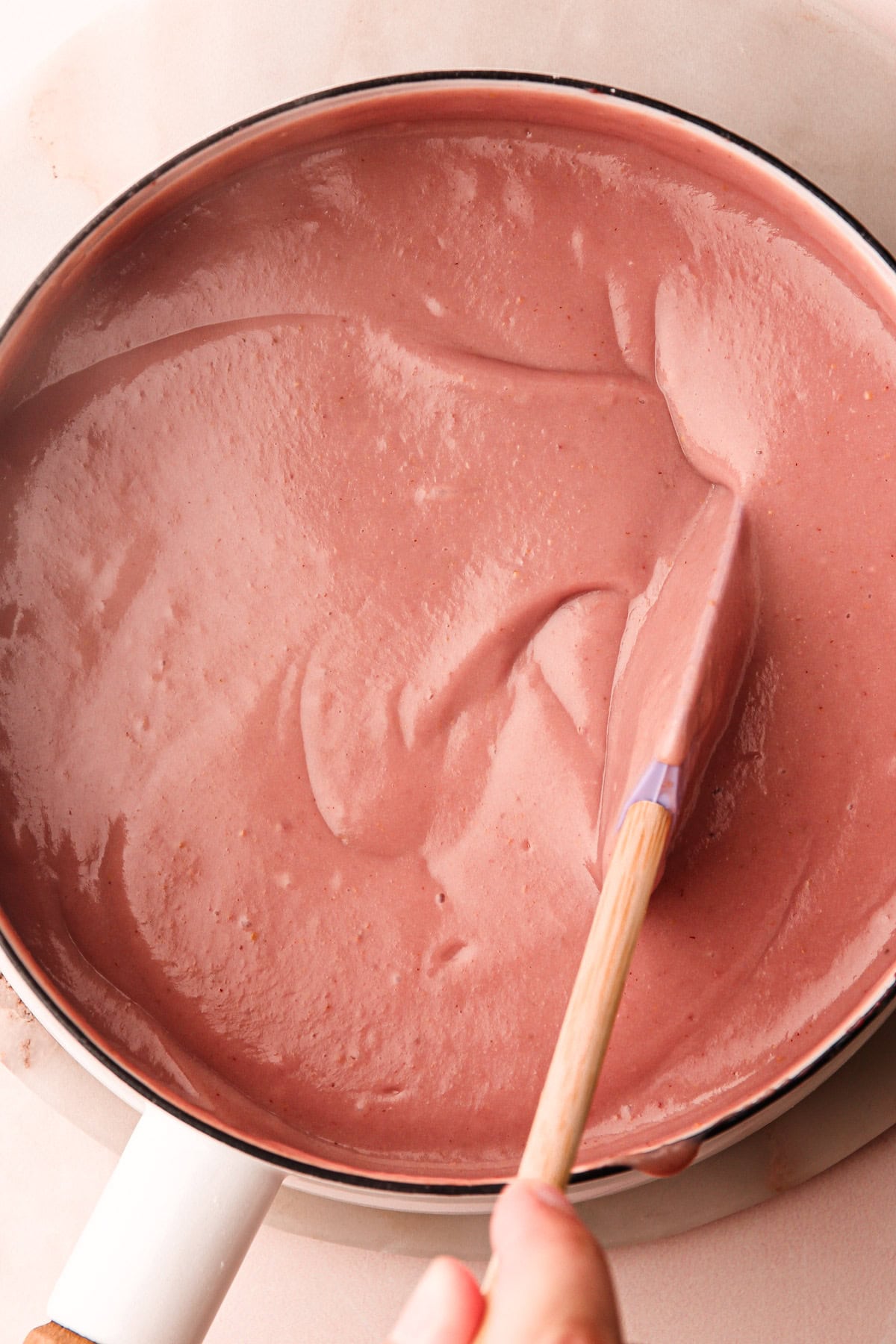 Cooked strawberry pudding in a pot before straining.