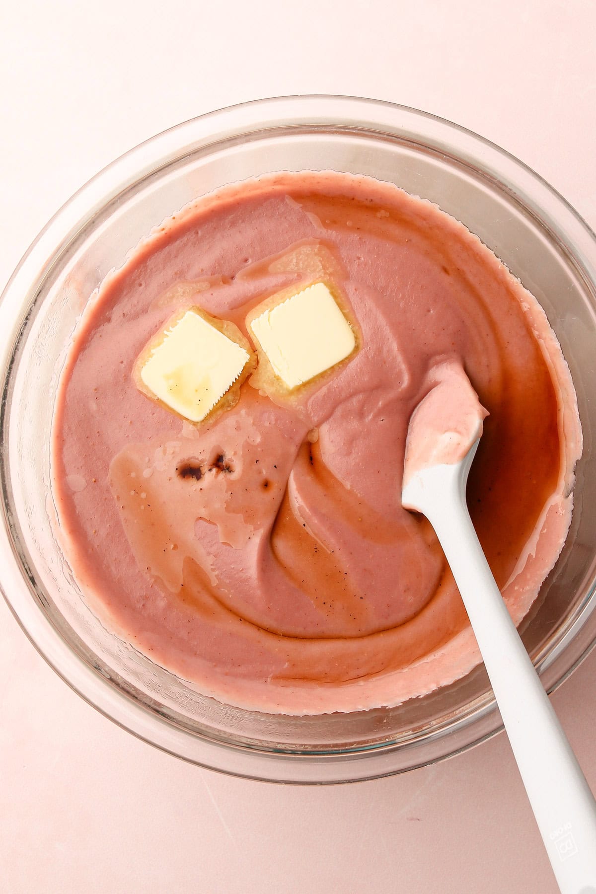 Adding butter and vanilla to a strawberry pudding recipe.