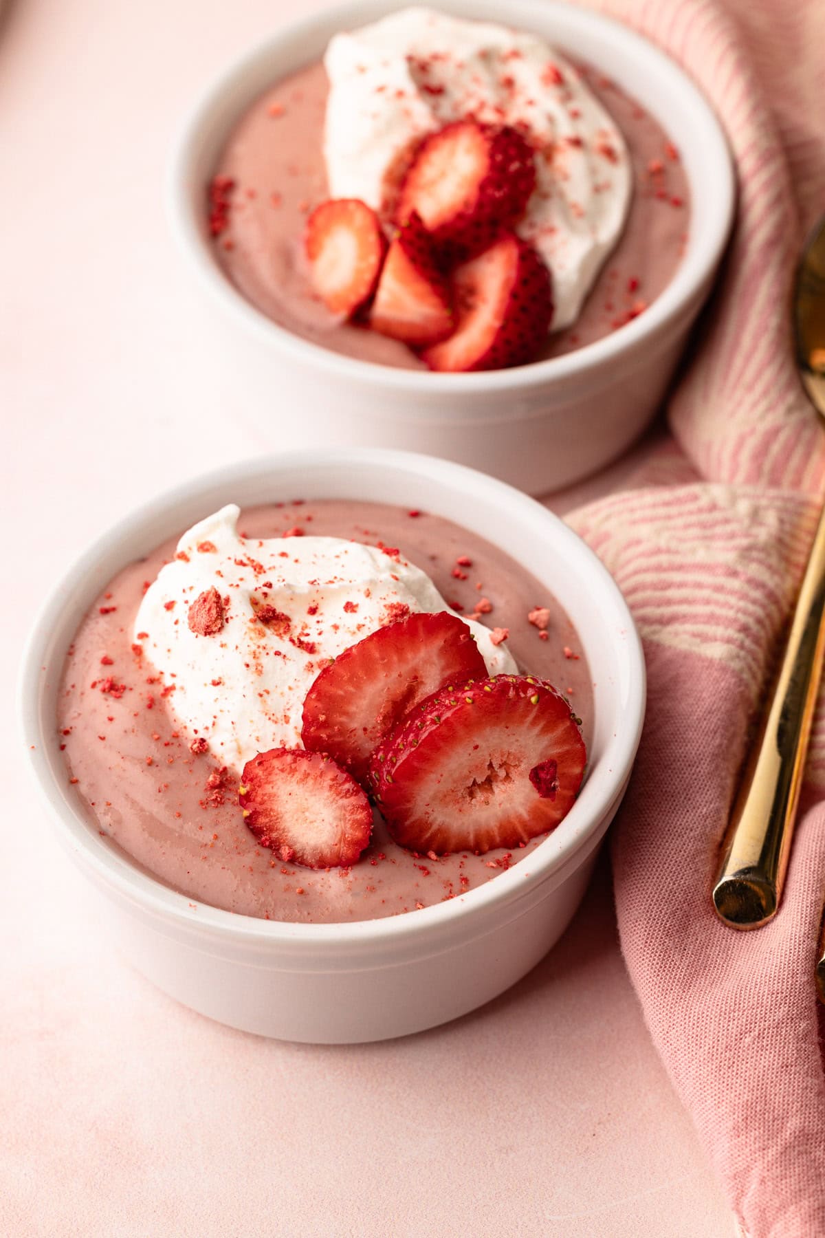 A serving of stovetop strawberry pudding made from scratch with cream and fresh strawberries.