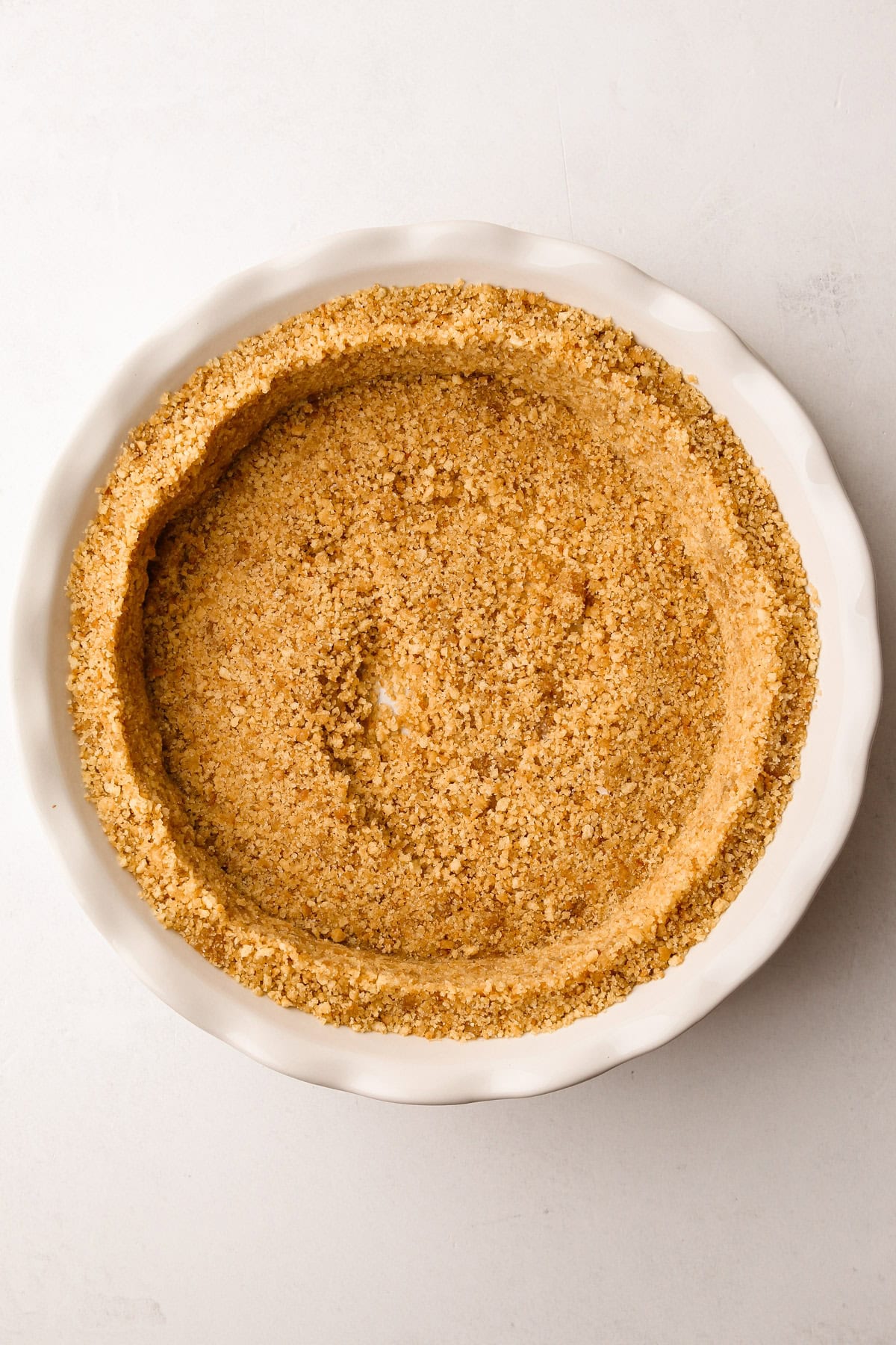 A vanilla wafer crumb crust mixture in a pie plate.