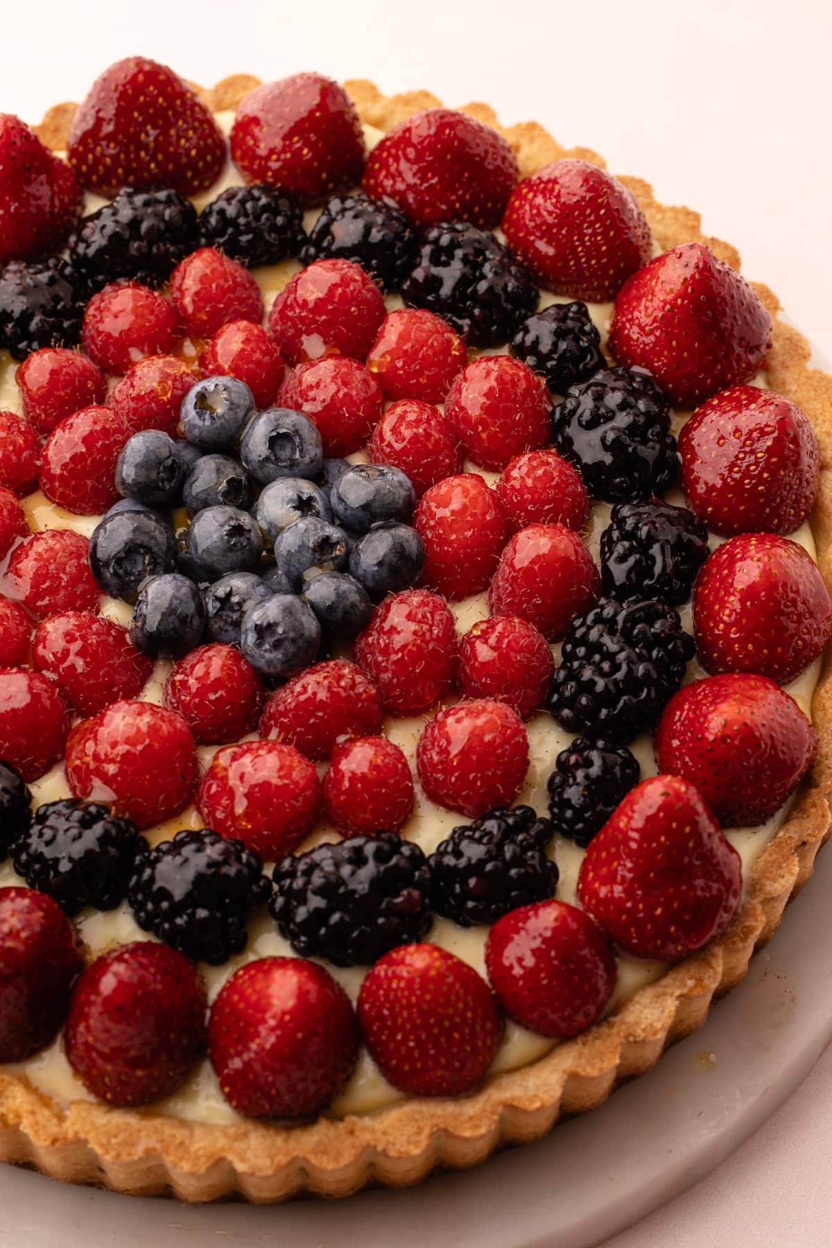 Fresh fruit tart filled with creamy pastry cream and topped with assorted fruits.