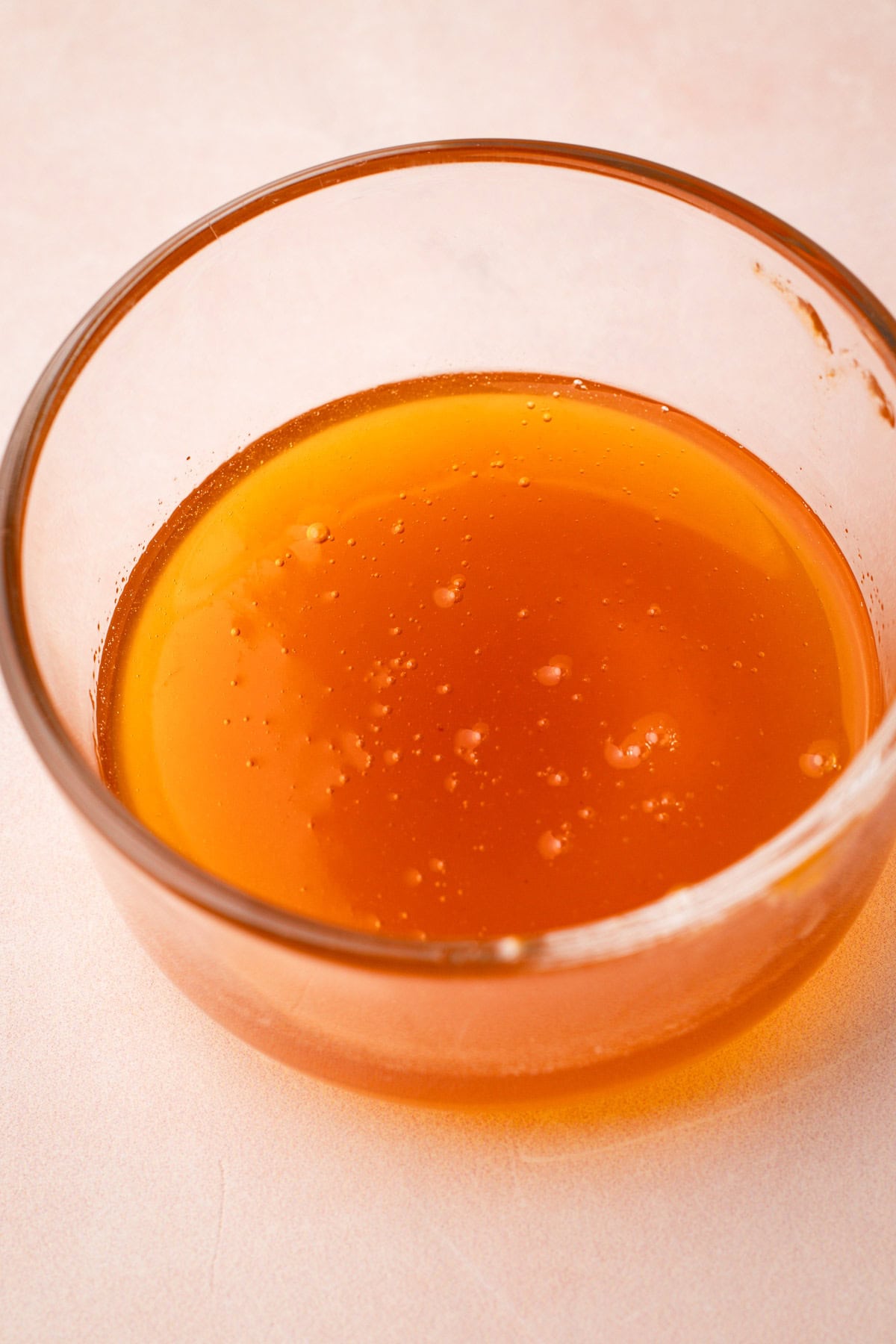 A bowl of heated apricot preserves ready to be used as a fruit glaze.