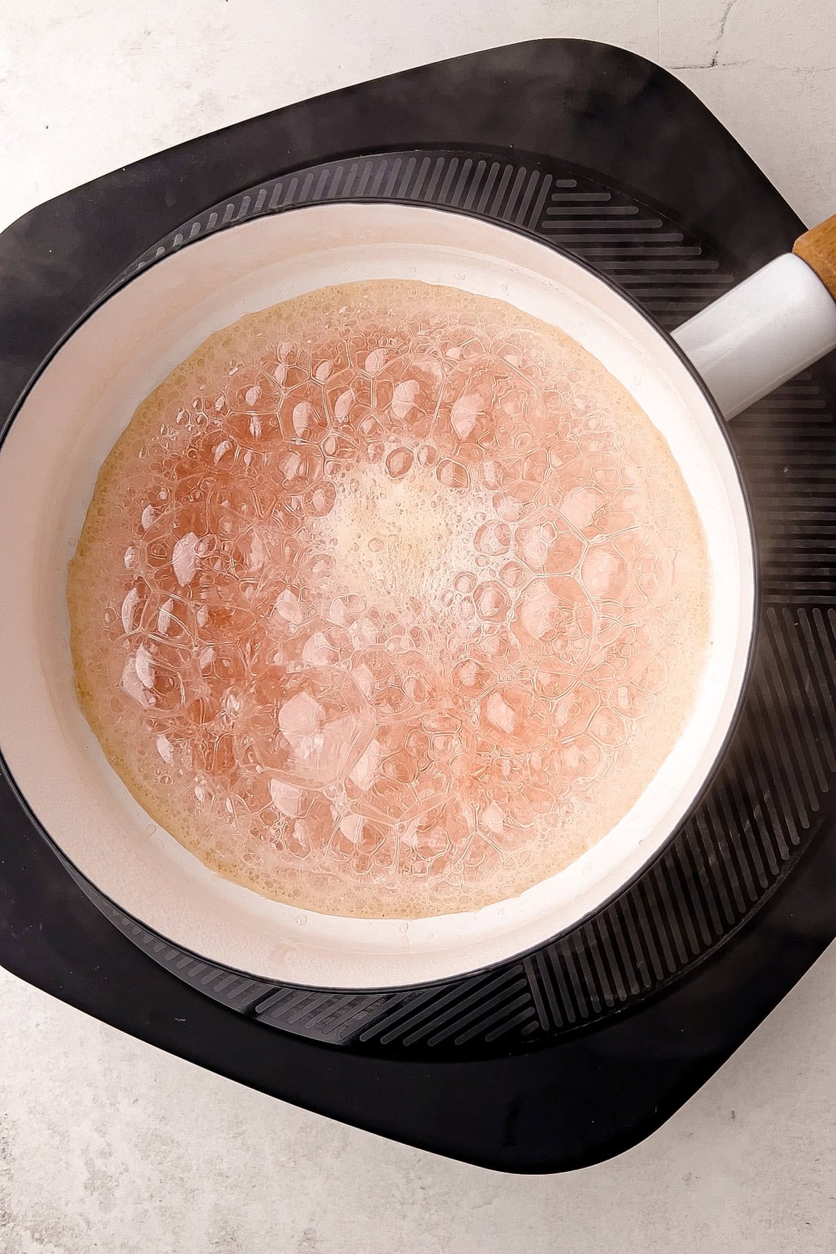 Sugar caramelizing for a peach tarte tatin recipe.