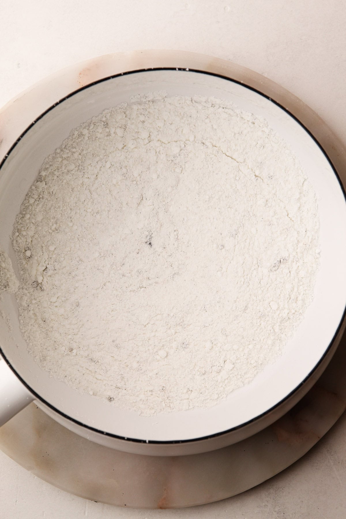 A pot containing dry ingredients for pastry cream.