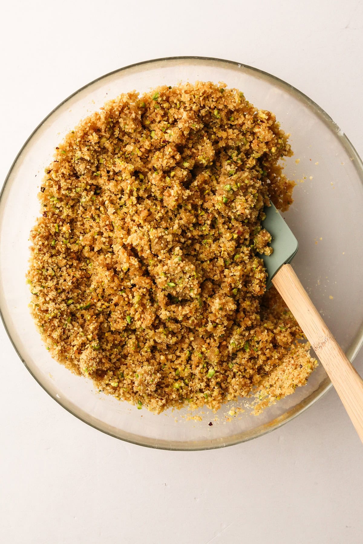 Pistachio and vanilla wafer crumb mixture in a bowl, ready for the cannoli pie crust.