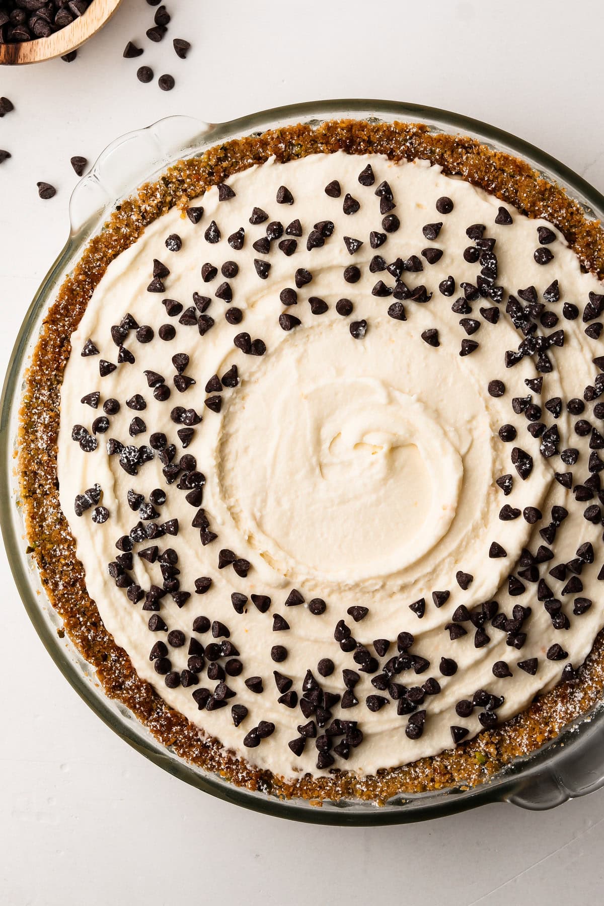 Prepared Cannoli pie topped with mini chocolate chips, ready to chill.