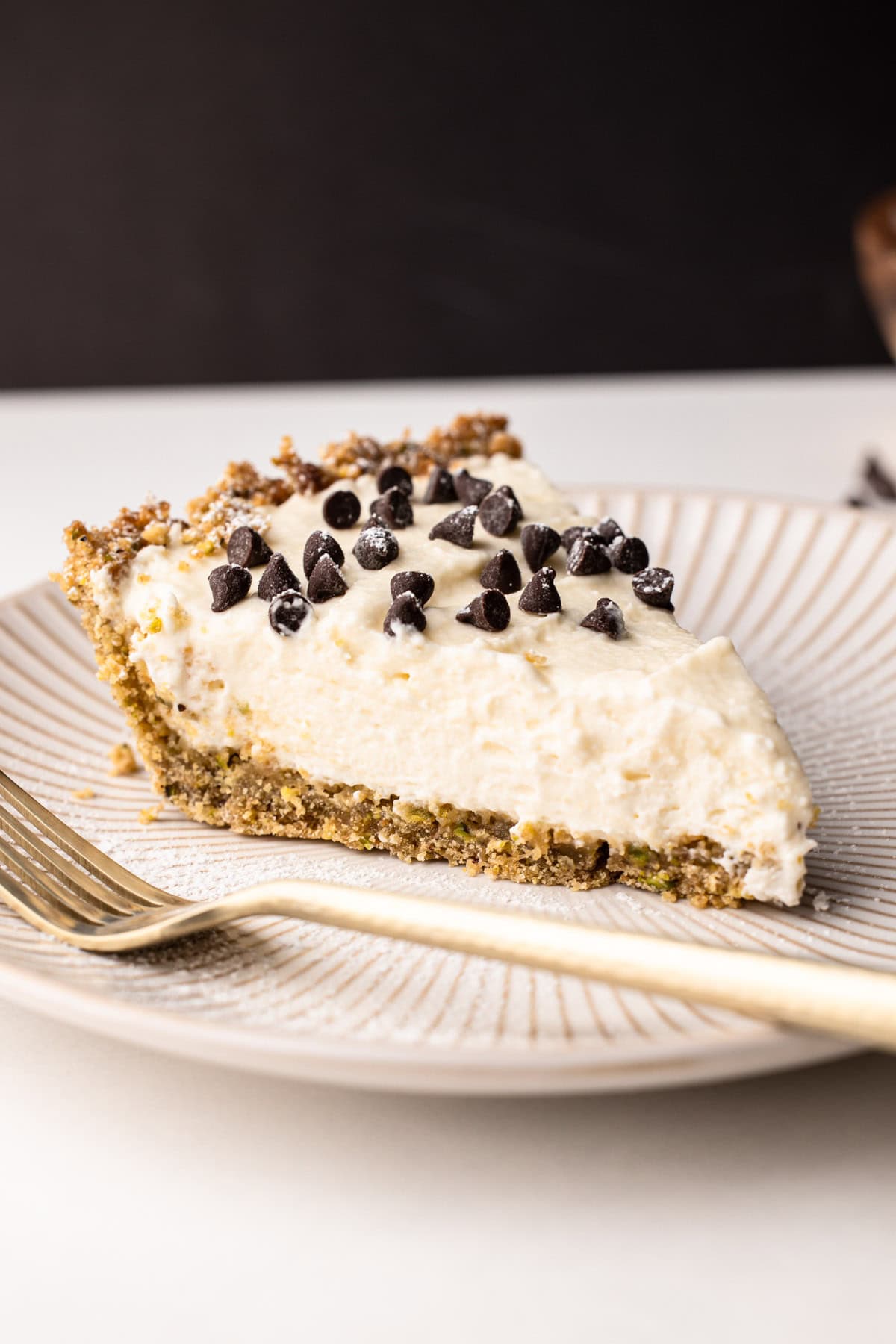 Close-up of a slice of easy cannoli pie with chocolate chips decorating it.