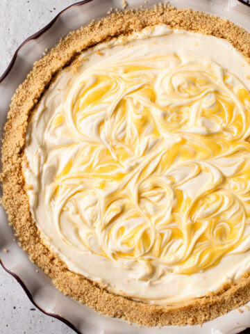 A no bake lemon pie with swirls of lemon curd on top.