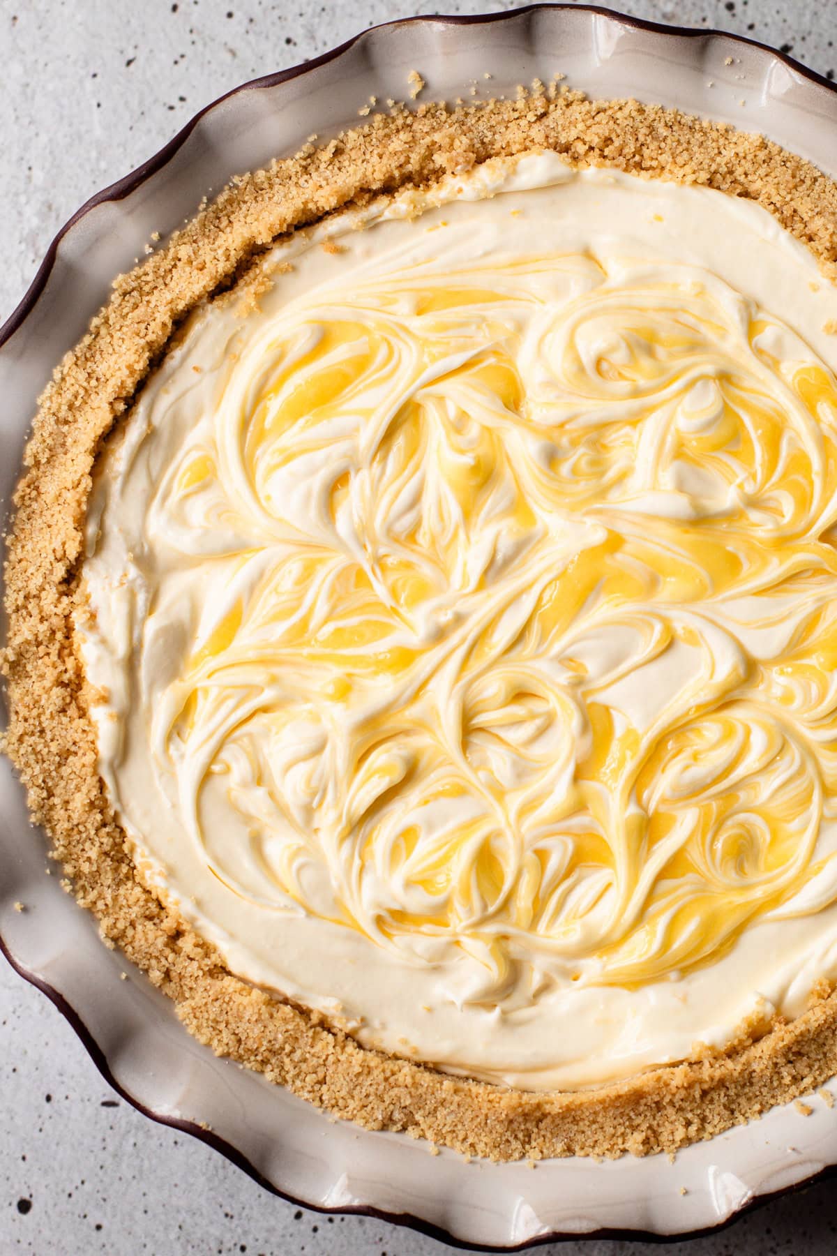 A no bake lemon pie with swirls of lemon curd on top.