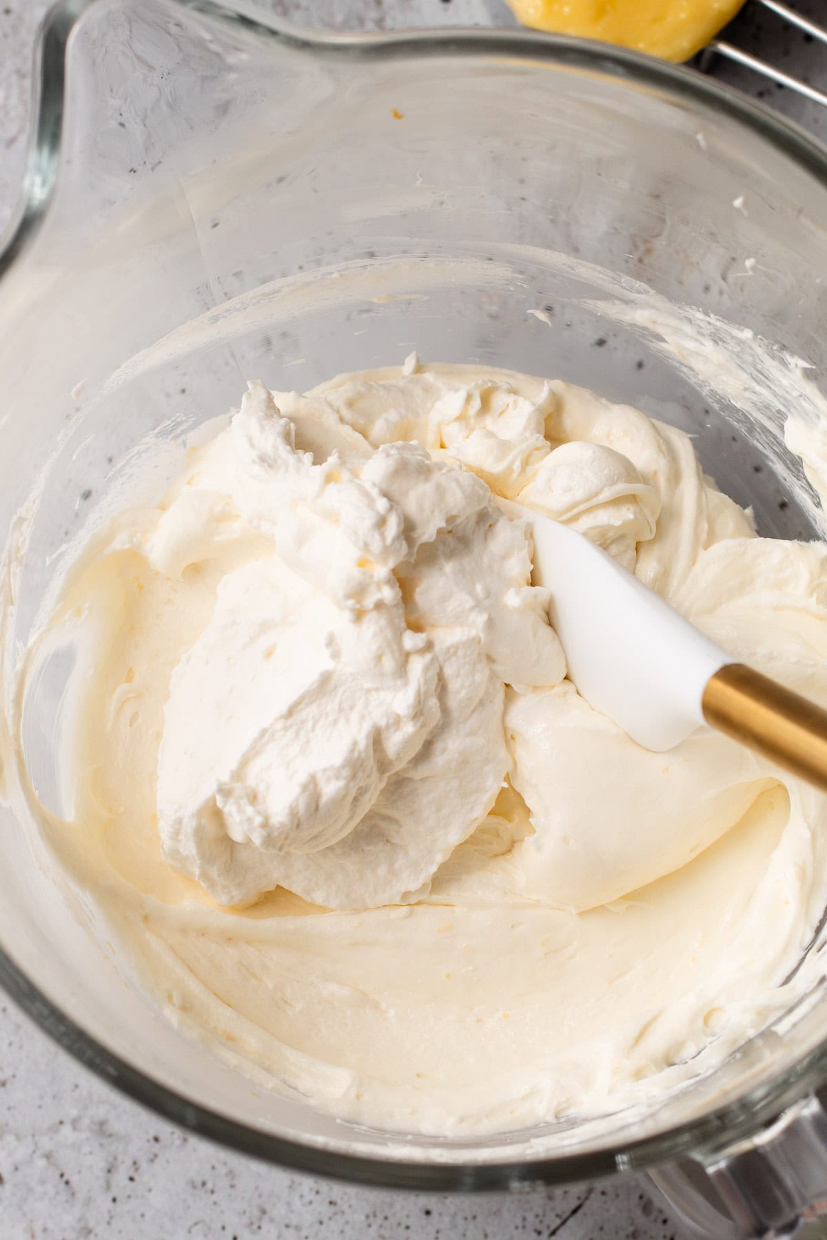 Freshly whipped cream in a glass mixing bowl.