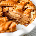 A gluten-free apple pie with a slice removed revealing the interior with juicy apples and perfect gluten free pie crust.