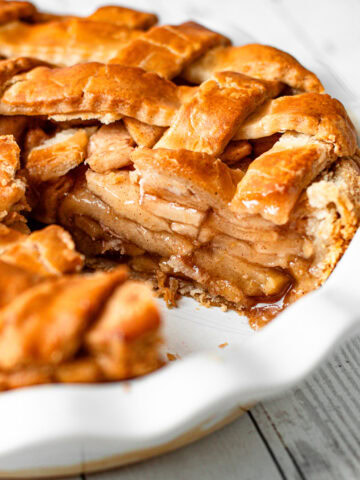 A gluten-free apple pie with a slice removed revealing the interior with juicy apples and perfect gluten free pie crust.